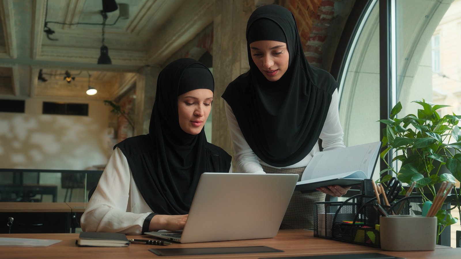 Muslim businesswomen Islamic girls business ladies women in hijab discuss laptop project corporate